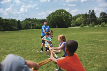 Children playing tug of war at YMCA summer camp.